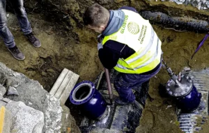 Montaż zaworu kulowego GLOBTOS w wykopie podczas prac przy sieci ciepłowniczej – instalacja spawanego zaworu DN na rurociągu stalowym